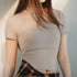 Woman wearing a beige knit top with text overlay on a plain background